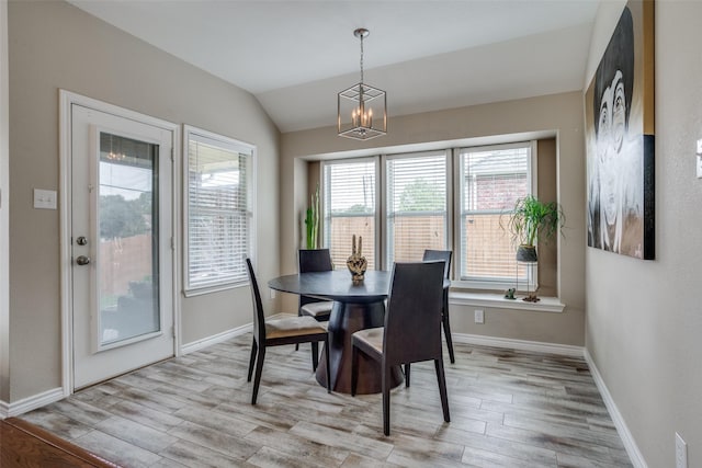 dining area featuring vaulted ceiling, an inviting chandelier, and light hardwood / wood-style floors