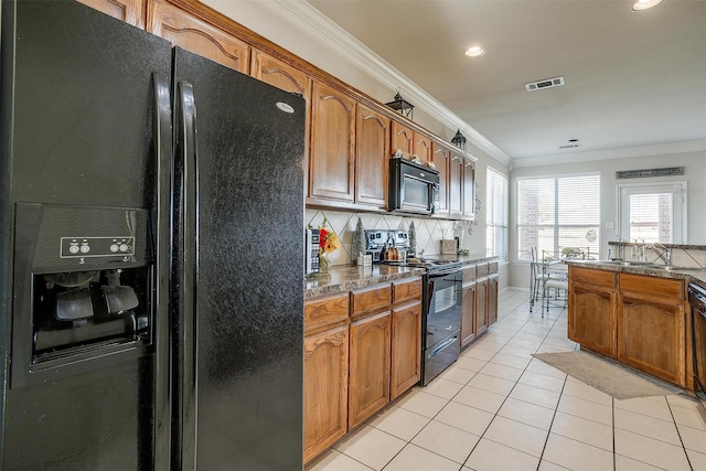 kitchen featuring light tile patterned flooring, black appliances, tasteful backsplash, and ornamental molding