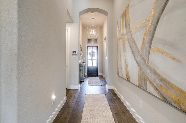 interior space featuring a chandelier, a towering ceiling, and dark hardwood / wood-style flooring