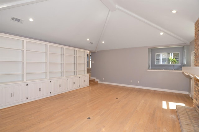 unfurnished living room with light wood-type flooring and lofted ceiling with beams