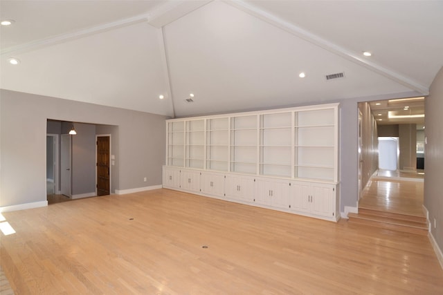 unfurnished living room featuring light hardwood / wood-style floors and vaulted ceiling with beams