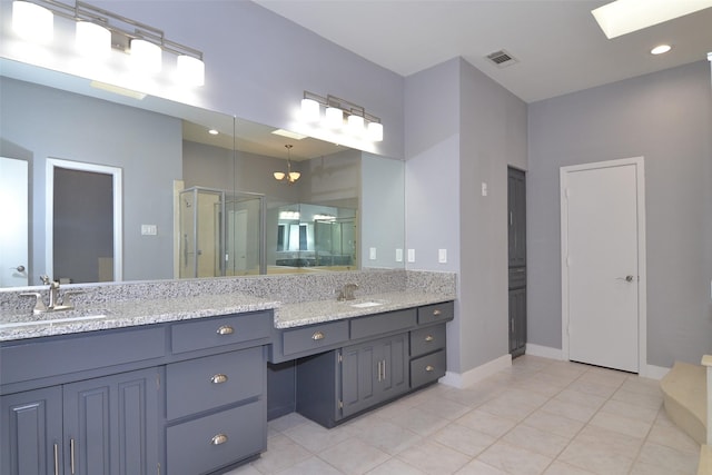 bathroom featuring tile patterned flooring, an enclosed shower, and vanity