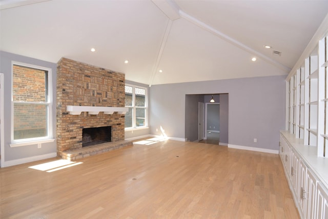 unfurnished living room with light wood-type flooring, lofted ceiling, and a fireplace