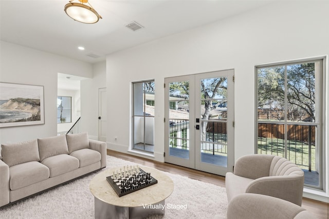 living room featuring french doors, a wealth of natural light, and wood-type flooring