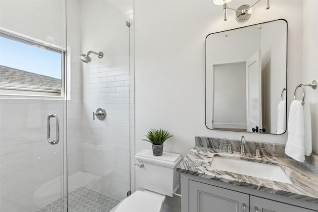 bathroom featuring toilet, vanity, and an enclosed shower