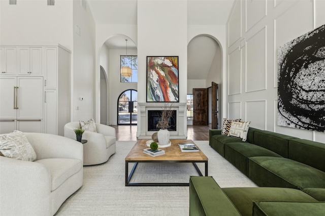 living room with light wood-type flooring and a high ceiling