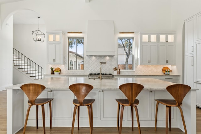 kitchen with light stone counters, white cabinetry, and a breakfast bar area