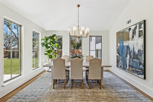 dining space with vaulted ceiling, a chandelier, plenty of natural light, and dark hardwood / wood-style flooring