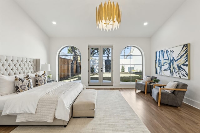 bedroom featuring french doors, hardwood / wood-style floors, lofted ceiling, and multiple windows