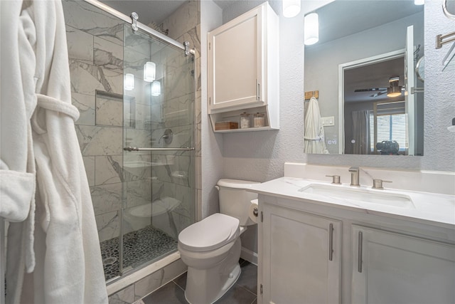 bathroom featuring vanity, a shower with shower door, toilet, and tile patterned flooring