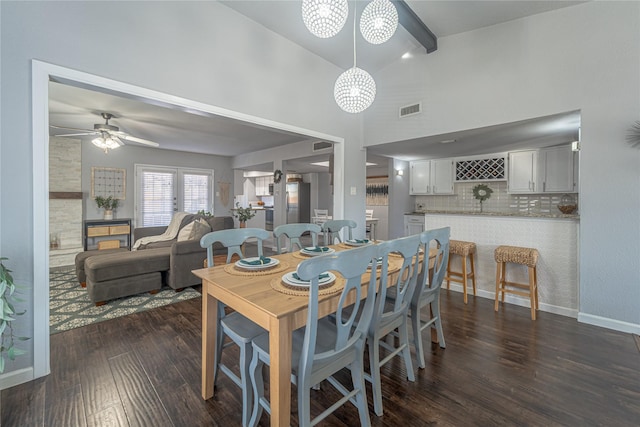 dining room with ceiling fan, vaulted ceiling with beams, and dark hardwood / wood-style flooring