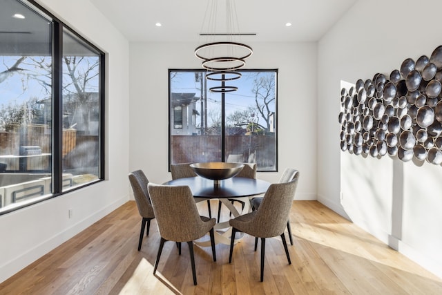 dining space with a notable chandelier and light hardwood / wood-style floors