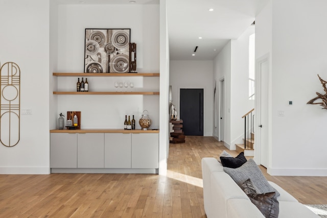 bar featuring light hardwood / wood-style flooring and white cabinets