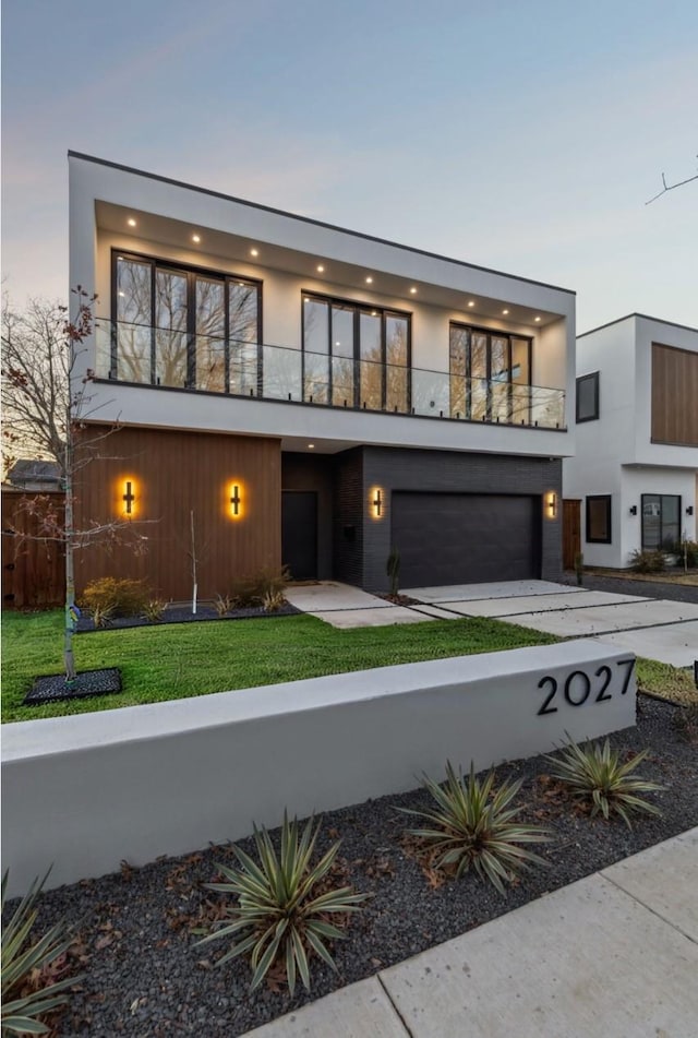 view of front of home featuring a garage and a balcony