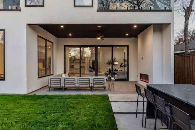 view of patio with a bar, ceiling fan, and an outdoor hangout area