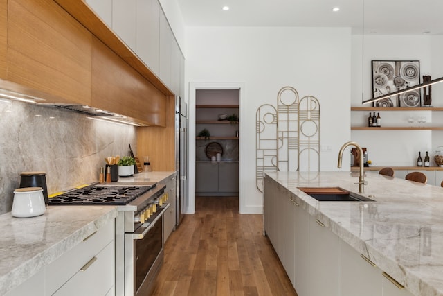 kitchen featuring white cabinetry, sink, stainless steel stove, and backsplash