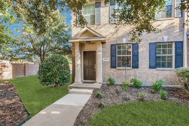 view of exterior entry with a yard