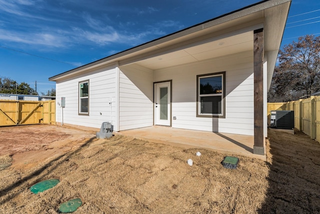 rear view of property with central AC unit and a patio area