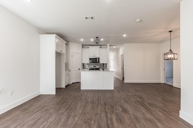 kitchen with white cabinetry, dark wood-type flooring, a kitchen island, and appliances with stainless steel finishes