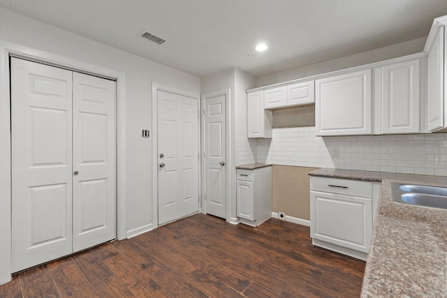 kitchen with sink, white cabinetry, dark hardwood / wood-style floors, and tasteful backsplash