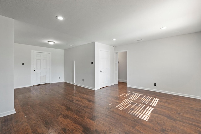 empty room with dark hardwood / wood-style flooring