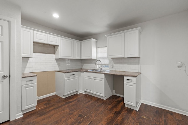 kitchen with sink, backsplash, white cabinets, and dark hardwood / wood-style flooring