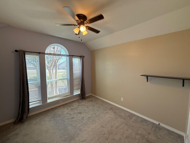 empty room featuring ceiling fan, light colored carpet, and lofted ceiling