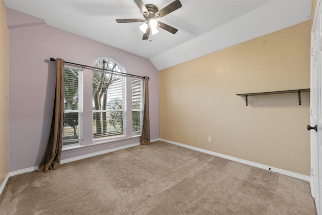 empty room with ceiling fan, light colored carpet, and lofted ceiling