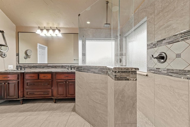 bathroom with vanity, tiled shower, and tile patterned floors