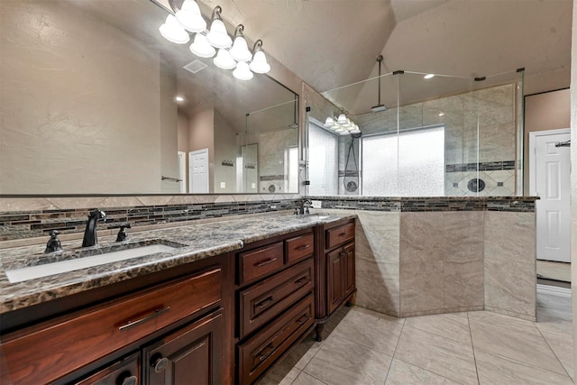 bathroom with tile walls, a shower with door, lofted ceiling, and vanity