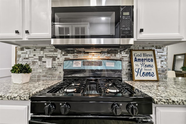 kitchen featuring white cabinets, backsplash, black gas range, and light stone counters