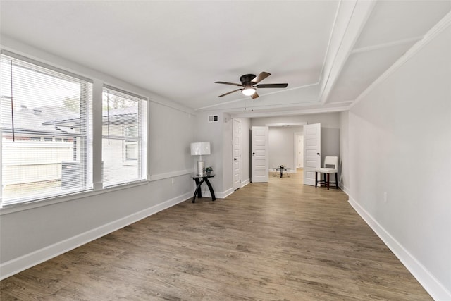 spare room with crown molding, dark wood-type flooring, and ceiling fan