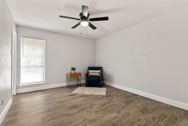 living area featuring ceiling fan and dark wood-type flooring