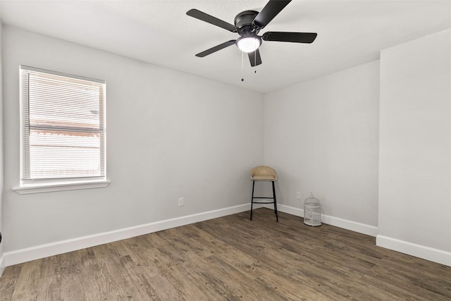 spare room with ceiling fan and dark wood-type flooring