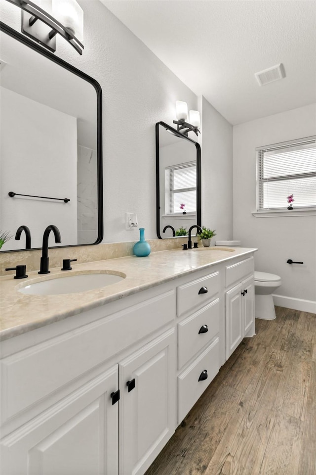 bathroom featuring vanity, toilet, hardwood / wood-style floors, and a textured ceiling