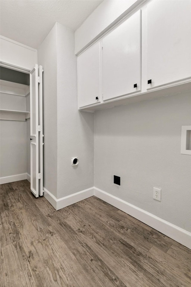 clothes washing area with washer hookup, electric dryer hookup, light hardwood / wood-style floors, and cabinets