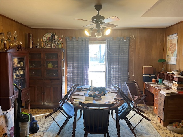 dining room featuring wooden walls and ceiling fan