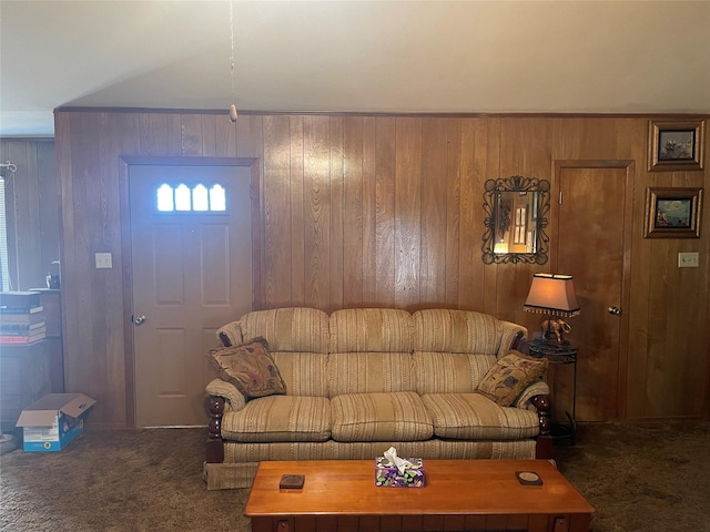 living room with wooden walls and dark colored carpet