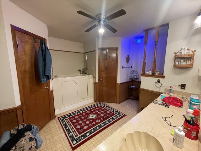 bathroom with vanity, washing machine and clothes dryer, wood walls, and ceiling fan