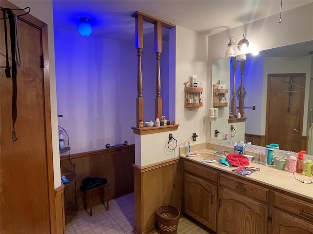 bathroom with vanity and wooden walls