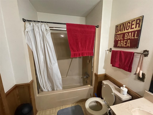 full bathroom featuring toilet, wooden walls, vanity, and shower / tub combo with curtain