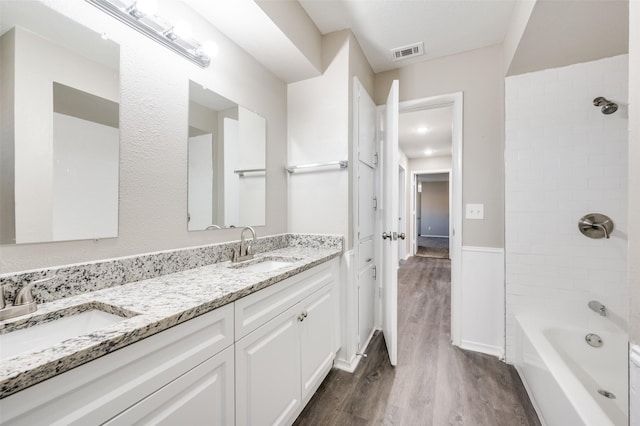 bathroom with vanity, hardwood / wood-style flooring, and tiled shower / bath combo