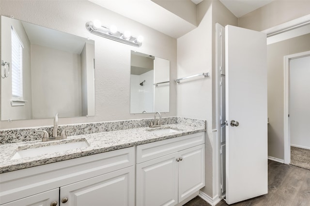 bathroom with a shower, wood-type flooring, and vanity