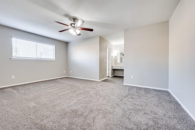 carpeted spare room featuring ceiling fan