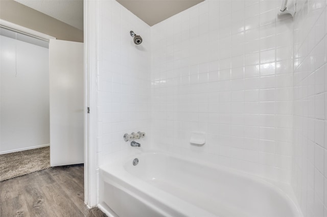 bathroom with bathtub / shower combination and hardwood / wood-style floors