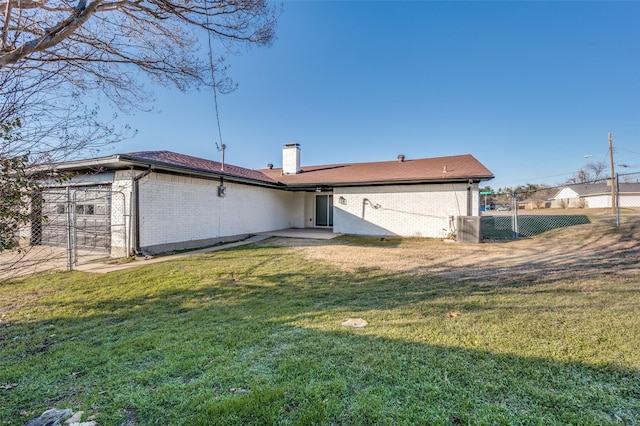 back of house featuring a lawn and central AC