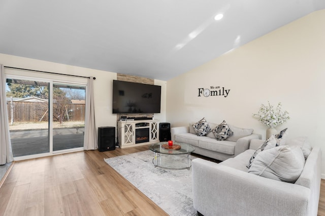 living room featuring a stone fireplace and hardwood / wood-style floors