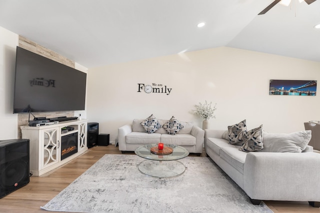 living room with lofted ceiling, light hardwood / wood-style flooring, and ceiling fan