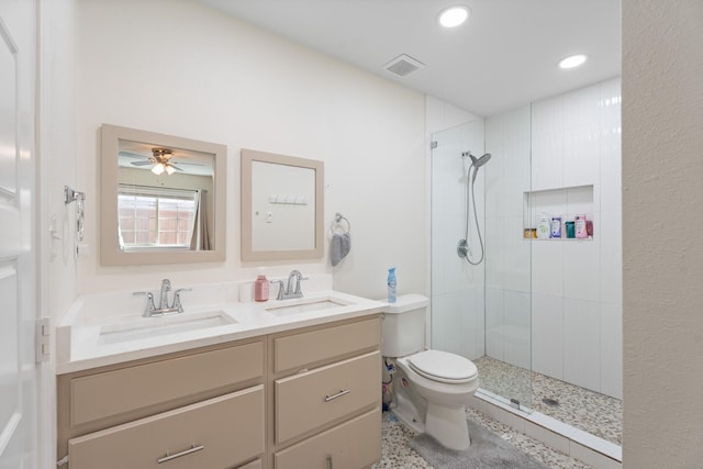 bathroom featuring vanity, a tile shower, and toilet