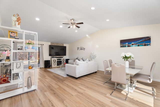 living room featuring ceiling fan, lofted ceiling, and light wood-type flooring